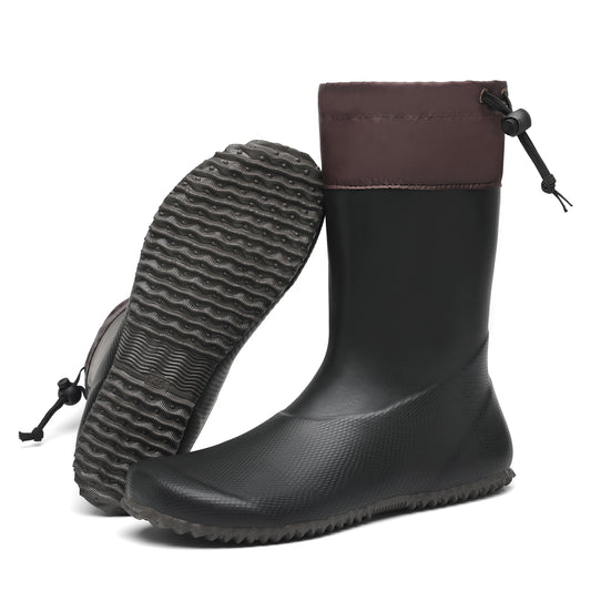 Black rubber boot with brown top and textured sole on a white background
